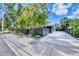 Home featuring a long driveway, dark grey privacy fence and tropical landscaping at 1919 Laurel St, Sarasota, FL 34236