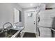 Convenient laundry room with a stainless steel sink and stacked washer and dryer at 1919 Laurel St, Sarasota, FL 34236