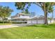 View of a two-story home with wrap around porch, three-car garage, and lush green lawn at 2002 8Th W St, Palmetto, FL 34221