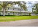 Inviting home showcasing a charming wrap-around porch and a well-maintained lawn with mature tree at 2002 8Th W St, Palmetto, FL 34221