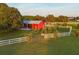 Aerial shot of red barn, paddocks, and white fencing on a sprawling ranch property at 20504 65Th E Ave, Bradenton, FL 34211