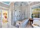 Elegant bathroom features a glass-enclosed shower, marble tile, and a view to a bright bedroom at 20504 65Th E Ave, Bradenton, FL 34211