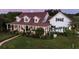 Elegant home featuring a wrap-around porch, dormer windows, and lush landscaping in a beautiful setting at 20504 65Th E Ave, Bradenton, FL 34211