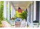 Inviting front porch with white columns, American flag, rocking chairs, and plants creating a cozy space at 20504 65Th E Ave, Bradenton, FL 34211