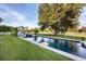 Beautiful backyard pool with a gazebo, lounge chairs, and mature trees on a well-manicured lawn at 20504 65Th E Ave, Bradenton, FL 34211