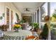 Screened porch with wicker furniture, ceiling fan and many potted plants around a table with a green tablecloth at 20504 65Th E Ave, Bradenton, FL 34211