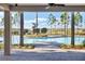 View of the community swimming pool from a covered area, framed by palm trees at 2105 Grand Flora Trl, Bradenton, FL 34208