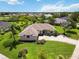 Aerial view showcases a home with lush landscaping, a well-kept lawn, and a paved driveway at 2199 Palm Ct, North Port, FL 34287