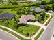 Aerial view of a well-maintained home with a spacious yard and circular driveway in a lovely neighborhood at 2199 Palm Ct, North Port, FL 34287