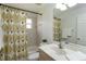 Cozy bathroom with a shower featuring a palm tree curtain, a toilet, and a single sink vanity at 2199 Palm Ct, North Port, FL 34287