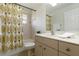 Cozy bathroom with a shower featuring a palm tree curtain, a toilet, and a single sink vanity at 2199 Palm Ct, North Port, FL 34287