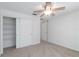 Well-lit bedroom boasting neutral carpet, a ceiling fan, a closet, and white doors at 2199 Palm Ct, North Port, FL 34287