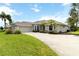 Charming home featuring a manicured lawn, mature palm trees, and a welcoming driveway at 2199 Palm Ct, North Port, FL 34287