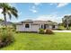Well-kept home with lush front lawn, tropical plants, and an inviting entrance, enhanced curb appeal at 2199 Palm Ct, North Port, FL 34287