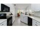 Clean kitchen with white cabinets, black appliances, and a bright eat-in nook at 2199 Palm Ct, North Port, FL 34287