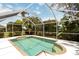 Refreshing pool enclosed in a screen, surrounded by trees for a private and relaxing setting at 2199 Palm Ct, North Port, FL 34287