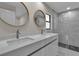 Modern bathroom featuring a double vanity and a luxurious glass-enclosed shower at 23367 Mayville Ave, Punta Gorda, FL 33980