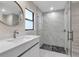 Contemporary bathroom featuring a marble-tiled shower with a glass door and modern fixtures at 23367 Mayville Ave, Punta Gorda, FL 33980