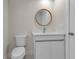 Bright bathroom featuring a modern vanity with marble countertop and stylish round mirror at 23367 Mayville Ave, Punta Gorda, FL 33980