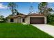 Charming one-story home boasts a well-manicured lawn, attached garage, and inviting curb appeal at 23367 Mayville Ave, Punta Gorda, FL 33980
