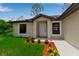 Inviting front entrance with meticulously maintained landscaping and white trim around the windows at 23367 Mayville Ave, Punta Gorda, FL 33980