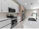 Close-up of kitchen with stainless steel appliances, white cabinets and quartz countertops at 23367 Mayville Ave, Punta Gorda, FL 33980