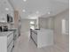 Modern kitchen features stainless steel appliances, white cabinets, and a large island with a sink at 23367 Mayville Ave, Punta Gorda, FL 33980