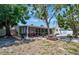 Spacious backyard featuring a screened lanai, picnic table, grill, and lush green landscaping at 2363 Milford Cir, Sarasota, FL 34239