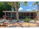 Charming backyard showcasing a covered porch, lush greenery, and a cozy picnic area at 2363 Milford Cir, Sarasota, FL 34239