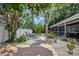 Charming backyard oasis with brick pavers, lounge chairs, picnic table, and lush tropical landscaping at 2363 Milford Cir, Sarasota, FL 34239