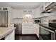 Bright kitchen featuring stainless steel appliances, farmhouse sink, granite countertops, and white cabinetry at 2363 Milford Cir, Sarasota, FL 34239
