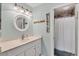 Bathroom with vanity, stylish round mirror, and a 