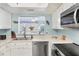 Bright kitchen features stainless steel appliances, white cabinetry, and a pass-through window to the living area at 2740 Orchid Oaks Dr # 304, Sarasota, FL 34239