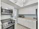 Updated kitchen with white cabinets, stainless steel appliances, and light wood-look flooring at 2740 Orchid Oaks Dr # 304, Sarasota, FL 34239