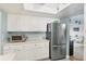 Bright kitchen with stainless steel refrigerator and white cabinetry, complemented by light tile floors at 2740 Orchid Oaks Dr # 304, Sarasota, FL 34239
