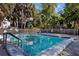 Community pool area with crystal clear water surrounded by lush landscaping and palm trees, perfect for outdoor relaxation at 2740 Orchid Oaks Dr # 304, Sarasota, FL 34239