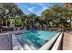 Community pool surrounded by lush greenery and mature trees at 2740 Orchid Oaks Dr # 304, Sarasota, FL 34239