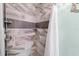 Modern shower features stylish, geometric tiling and convenient shower shelving at 2740 Orchid Oaks Dr # 304, Sarasota, FL 34239