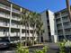 Exterior view of community Building O with large balconies, landscaping, and parking at 3272 Lake Bayshore Dr # 515, Bradenton, FL 34205