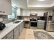 Well-lit kitchen featuring stainless steel appliances, a mosaic backsplash, and light wood flooring at 3272 Lake Bayshore Dr # 515, Bradenton, FL 34205
