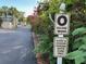 Community street view with palm trees, colorful plants, and O building directional sign at 3272 Lake Bayshore Dr # 515, Bradenton, FL 34205