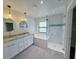 A luxury bathroom with a double sink vanity, modern tub, and a glass-enclosed shower at 3387 Tupelo Ave, North Port, FL 34286