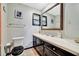 A bathroom with a toilet and vanity with mirror at 3428 Mineola Dr, Sarasota, FL 34239