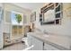 Quaint bathroom featuring a marble vanity, large mirror, and natural lighting at 3428 Mineola Dr, Sarasota, FL 34239