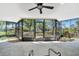 A sunny sunroom with screened windows, ceiling fan, and a view of lush greenery outside at 3428 Mineola Dr, Sarasota, FL 34239