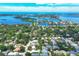 Expansive aerial view of a coastal neighborhood with a mix of homes, lush foliage, and stunning waterfront views at 3837 Camino Real, Sarasota, FL 34239