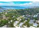 Scenic aerial view of a waterfront community with lush trees, showcasing many homes and a view of the intercoastal waterway at 3837 Camino Real, Sarasota, FL 34239