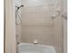 Standard bathtub and shower with tile surround and simple fixtures with shower curtain at 3837 Camino Real, Sarasota, FL 34239