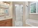 Bathroom with a glass-enclosed shower, soaking tub, and vanity with countertop at 3837 Camino Real, Sarasota, FL 34239