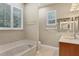 Bathroom featuring a soaking tub, ample lighting, and neutral-toned finishes at 3837 Camino Real, Sarasota, FL 34239